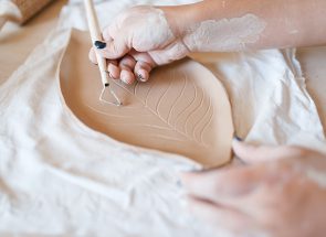 female-potter-draws-a-pattern-pottery-workshop-XWPCZ9D.jpg